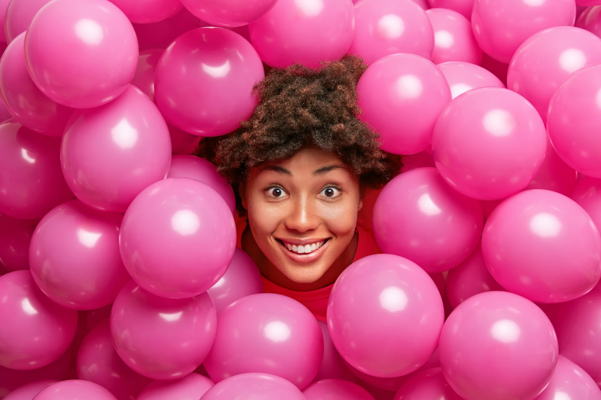 Guest smiling among pink balloons at a Tamba event